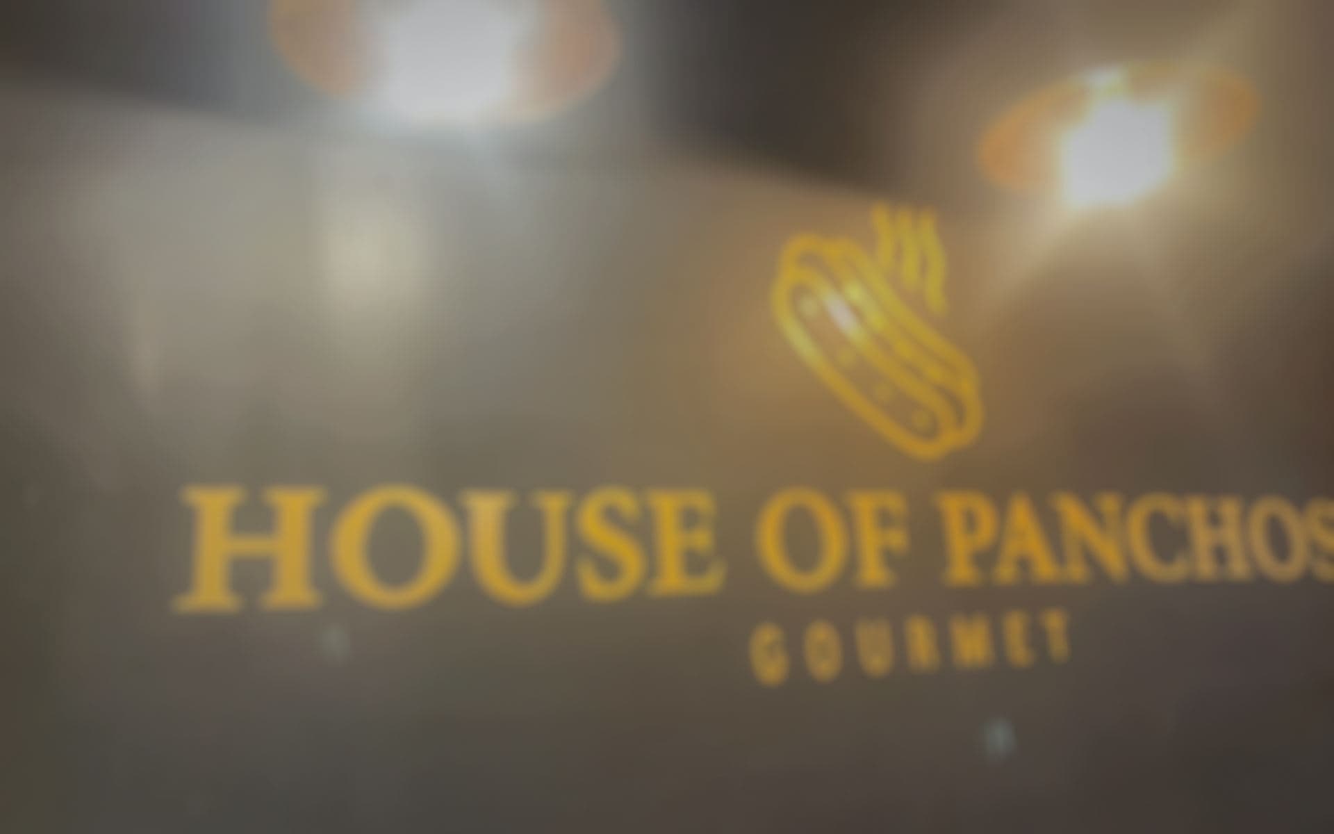 Web de House of Panchos sobre una foto de la pared del local.